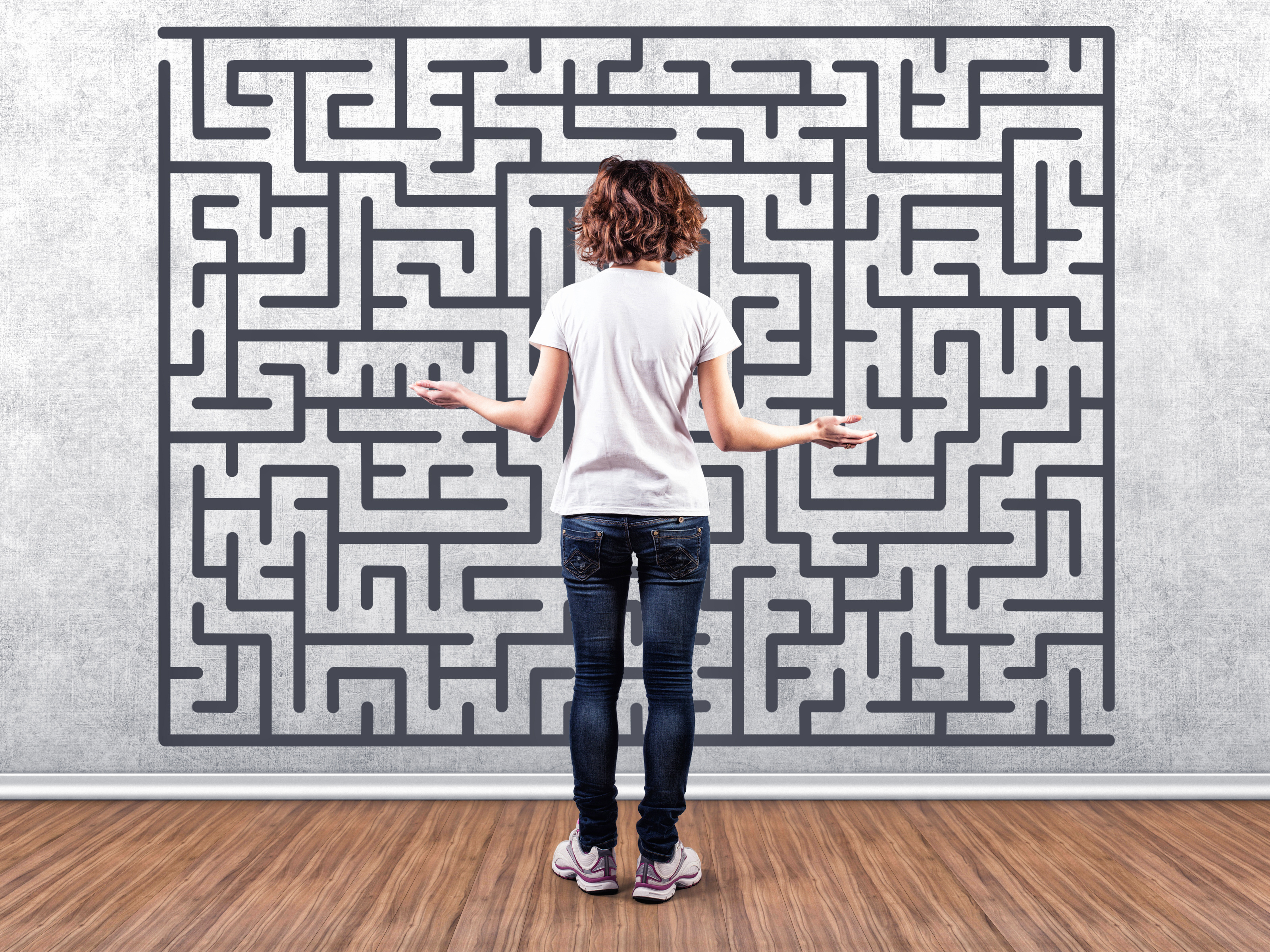 Frau steht ratlos vor einem aufgemalten Labyrinth
