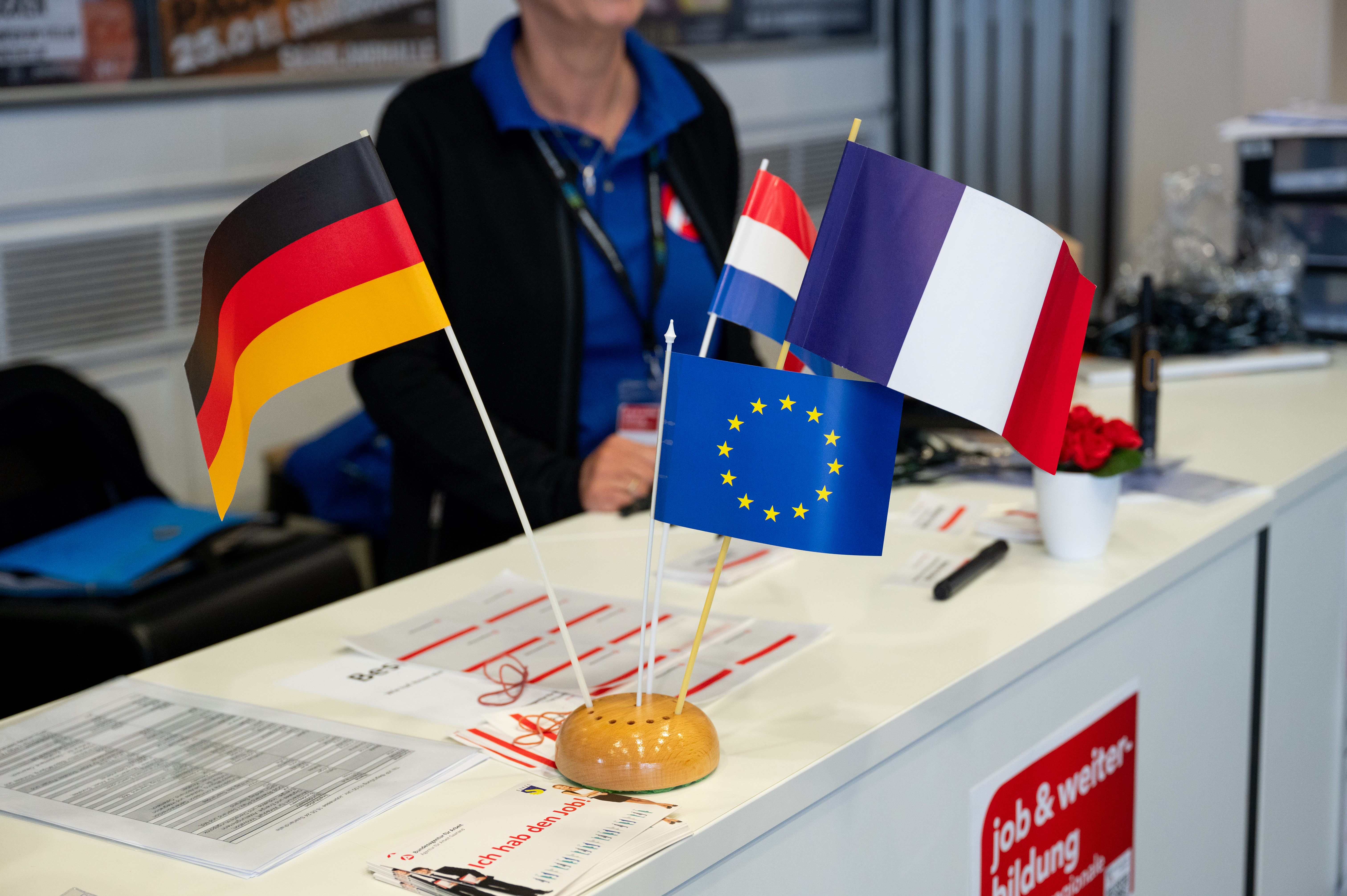 Tisch mit Ständer in denen vier Flaggen stecken